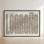Framed Logroño in Extra Compressed design, where the letters are tightly squeezed to fit the city's map shape designed in light brown and an off-white background with no border edge-to-edge print leaning against a wall