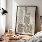 Diseño de interiores moderno con la lámina de Lugo en el diseño la Revoltosa, donde las letras del nombre aparecen aleatoriamente en diferentes líneas para un diseño urbano realmente original diseñado en marrón claro y fondo blanco roto, expuesto en la pared de un salón