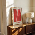 Modern interior design with a Malasaña, Madrid, in Super Bold design, a typographic poster where the city map is overlaid with extra-thick lettering for a modern, high-impact look designed in red and an off-white background, displayed on a living room wall