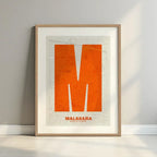 Framed Malasaña, Madrid, in Super Bold design, a typographic poster where the city map is overlaid with extra-thick lettering for a modern, high-impact look designed in orange and an off-white background with a white margin border in a warm lit minimalist setting
