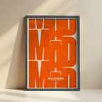 Framed Malasaña, Madrid, in Inseparable design, featuring the city's abbreviation in expressive typography over a detailed urban map designed in orange and an off-white background with no border edge-to-edge print leaning against a wall