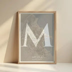 Cuadro de Melilla en el diseño La Clásica, inspirado en la tipografía cincelada con una fuente elegante que crea un bonito contraste visual diseñado en marrón claro y fondo blanco roto con impresión sin márgenes, apoyado contra la pared