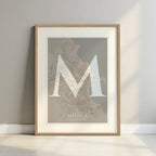 Framed Melilla in Classic design, inspired by chiseled typography with an elegant font that creates a beautiful visual contrast designed in light brown and an off-white background with a white margin border in a warm lit minimalist setting