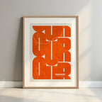 Framed Ourense in Inseparable design, featuring the city's abbreviation in expressive typography over a detailed urban map designed in orange and an off-white background with a white margin border in a warm lit minimalist setting