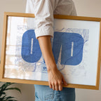 Modern interior design with a Oviedo in Super Bold design, a typographic poster where the city map is overlaid with extra-thick lettering for a modern, high-impact look designed in navy blue and white, displayed on a living room wall