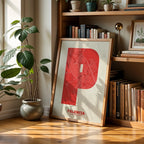 Diseño de interiores moderno con la lámina de Palencia en mi diseño la Súper Bold, un póster tipográfico donde el mapa de la ciudad se fusiona con una tipografía extra gruesa para un impacto visual moderno diseñado en rojo y fondo blanco roto, expuesto en la pared de un salón