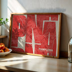 Modern interior design with a Pamplona in Inseparable design, featuring the city's abbreviation in expressive typography over a detailed urban map designed in red and an off-white background, displayed on a living room wall