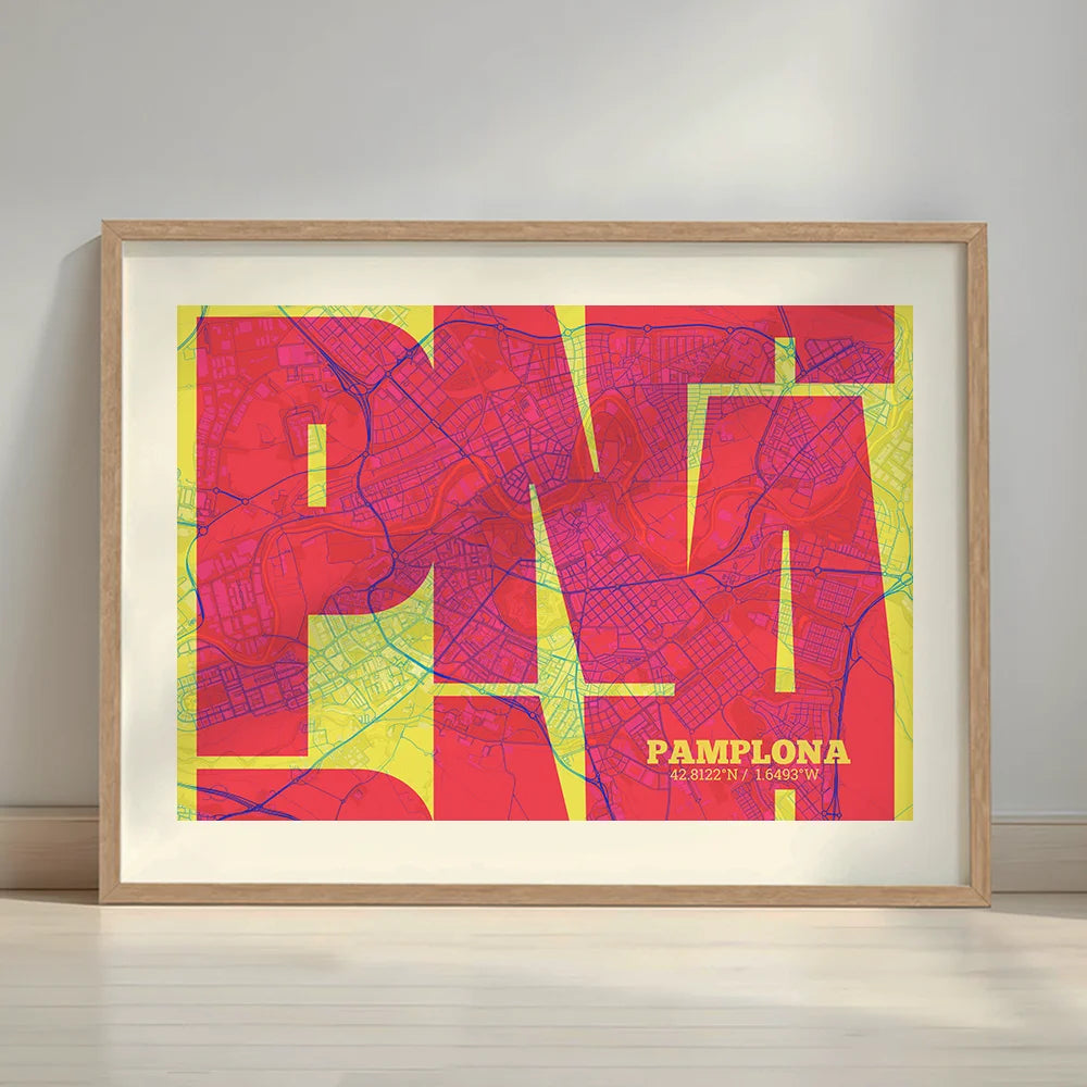 Framed Pamplona in Inseparable design, featuring the city's abbreviation in expressive typography over a detailed urban map designed in yellow and fuchsia with a white margin border in a warm lit minimalist setting