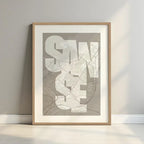 Framed San Sebastian de los Reyes in Inseparable design, featuring the city's abbreviation in expressive typography over a detailed urban map designed in light brown and an off-white background with a white margin border in a warm lit minimalist setting