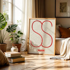 Modern interior design with a San Sebastian de los Reyes in Ultralight design, a minimalist aesthetic combining urban cartography with modern, extra-thin elegant lettering designed in red and an off-white background, displayed on a living room wall