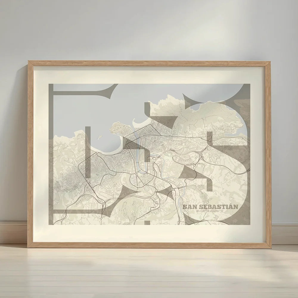 Framed San Sebastian in Inseparable design, featuring the city's abbreviation in expressive typography over a detailed urban map designed in light brown and an off-white background with a white margin border in a warm lit minimalist setting