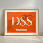 Framed San Sebastian in Classic design, inspired by chiseled typography with an elegant font that creates a beautiful visual contrast designed in orange and an off-white background with a white margin border in a warm lit minimalist setting