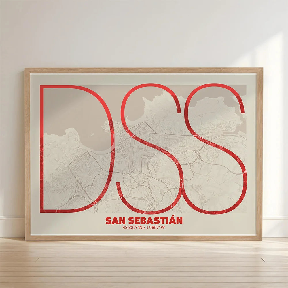 Framed San Sebastian in Ultralight design, a minimalist aesthetic combining urban cartography with modern, extra-thin elegant lettering designed in red and an off-white background with no border edge-to-edge print leaning against a wall