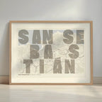 Framed San Sebastian in Unruled design, where the city name letters appear randomly across different lines for a truly original urban layout designed in light brown and an off-white background with a white margin border in a warm lit minimalist setting