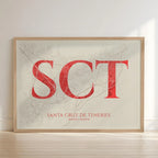 Framed Santa Cruz de Tenerife in Classic design, inspired by chiseled typography with an elegant font that creates a beautiful visual contrast designed in red and an off-white background with no border edge-to-edge print leaning against a wall