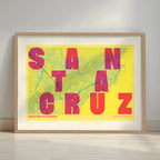 Framed Santa Cruz de Tenerife in Unruled design, where the city name letters appear randomly across different lines for a truly original urban layout designed in yellow and fuchsia with a white margin border in a warm lit minimalist setting
