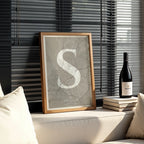 Diseño de interiores moderno con la lámina de Santiago de Compostela en el diseño La Clásica, inspirado en la tipografía cincelada con una fuente elegante que crea un bonito contraste visual diseñado en marrón claro y fondo blanco roto, expuesto en la pared de un salón