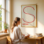 Diseño de interiores moderno con la lámina de Santiago de Compostela en el diseño la Ultrafina, una estética minimalista que combina cartografía urbana con letras modernas, finas y elegantes diseñado en rojo y fondo blanco roto, expuesto en la pared de un salón