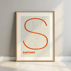 Framed Santiago de Compostela in Ultralight design, a minimalist aesthetic combining urban cartography with modern, extra-thin elegant lettering designed in orange and an off-white background with a white margin border in a warm lit minimalist setting