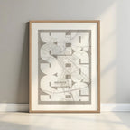 Framed Segovia in Inseparable design, featuring the city's abbreviation in expressive typography over a detailed urban map designed in light brown and an off-white background with a white margin border in a warm lit minimalist setting