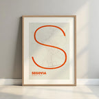Framed Segovia in Ultralight design, a minimalist aesthetic combining urban cartography with modern, extra-thin elegant lettering designed in orange and an off-white background with a white margin border in a warm lit minimalist setting