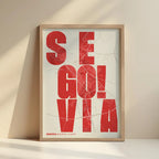 Cuadro de Segovia en el diseño la Revoltosa, donde las letras del nombre aparecen aleatoriamente en diferentes líneas para un diseño urbano realmente original diseñado en rojo y fondo blanco roto con impresión sin márgenes, apoyado contra la pared