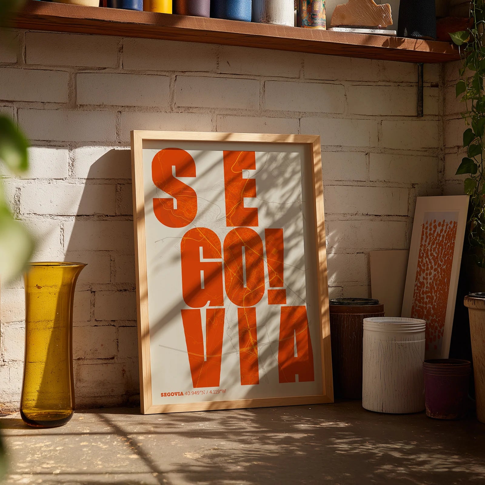 Modern interior design with a Segovia in Unruled design, where the city name letters appear randomly across different lines for a truly original urban layout designed in orange and an off-white background, displayed on a living room wall