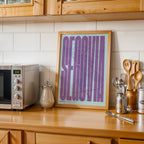Modern interior design with a Segovia in Extra Compressed design, where the letters are tightly squeezed to fit the city's map shape designed in purple and light blue, displayed on a living room wall