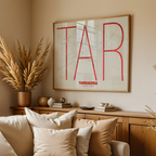 Diseño de interiores moderno con la lámina de Tarragona en el diseño la Ultrafina, una estética minimalista que combina cartografía urbana con letras modernas, finas y elegantes diseñado en rojo y fondo blanco roto, expuesto en la pared de un salón