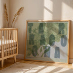 Modern interior design with a Tarragona in Unruled design, where the city name letters appear randomly across different lines for a truly original urban layout designed in two green tones, displayed on a living room wall