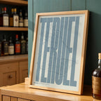 Modern interior design with a Teruel in Extra Compressed design, where the letters are tightly squeezed to fit the city's map shape designed in bluish gray and an off-white background, displayed on a living room wall