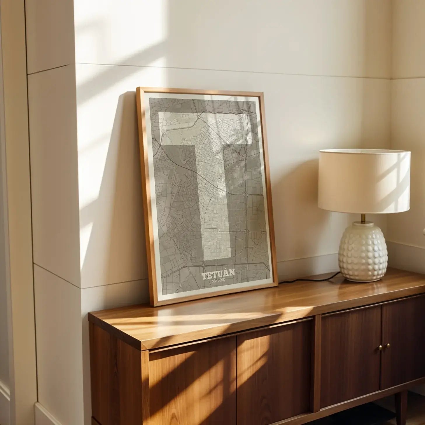 Diseño de interiores moderno con la lámina del barrio de Tetuán, Madrid, en diseño la Súper Bold, un póster tipográfico donde el mapa de la ciudad se fusiona con una tipografía extra gruesa para un impacto visual moderno diseñado en marrón claro y fondo blanco roto, expuesto en la pared de un salón