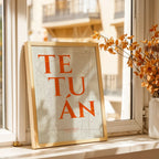 Diseño de interiores moderno con la lámina del barrio de Tetuán, Madrid, en el diseño la Clásica, inspirado en la tipografía cincelada con una fuente elegante que crea un bonito contraste visual diseñado en naranja y fondo blanco roto, expuesto en la pared de un salón