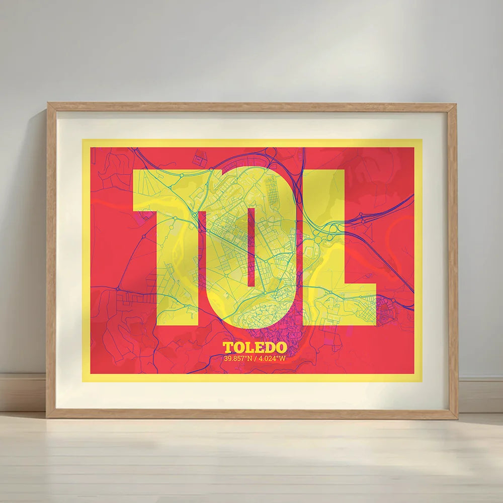 Framed Toledo in Super Bold design, a typographic poster where the city map is overlaid with extra-thick lettering for a modern, high-impact look designed in yellow and fuchsia with a white margin border in a warm lit minimalist setting