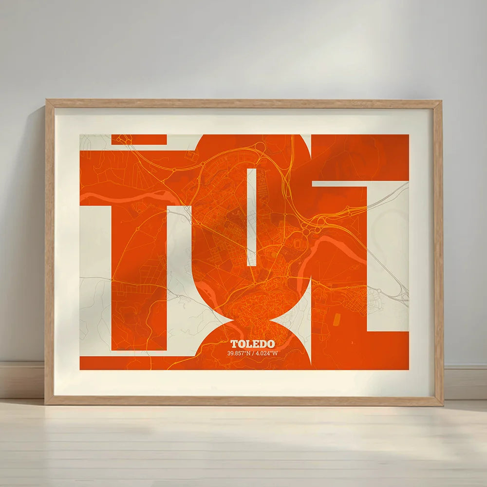 Framed Toledo in Inseparable design, featuring the city's abbreviation in expressive typography over a detailed urban map designed in orange and an off-white background with a white margin border in a warm lit minimalist setting