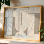Modern interior design with a Toledo in Inseparable design, featuring the city's abbreviation in expressive typography over a detailed urban map designed in light brown and an off-white background, displayed on a living room wall