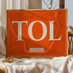 Modern interior design with a Toledo in Classic design, inspired by chiseled typography with an elegant font that creates a beautiful visual contrast designed in orange and an off-white background, displayed on a living room wall