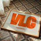 Modern interior design with a Valencia in Super Bold design, a typographic poster where the city map is overlaid with extra-thick lettering for a modern, high-impact look designed in orange and an off-white background, displayed on a living room wall