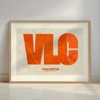 Framed Valencia in Super Bold design, a typographic poster where the city map is overlaid with extra-thick lettering for a modern, high-impact look designed in orange and an off-white background with a white margin border in a warm lit minimalist setting