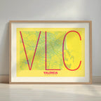 Framed Valencia in Ultralight design, a minimalist aesthetic combining urban cartography with modern, extra-thin elegant lettering designed in yellow and fuchsia with a white margin border in a warm lit minimalist setting