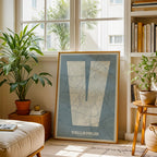 Diseño de interiores moderno con la lámina de Valladolid en mi diseño la Súper Bold, un póster tipográfico donde el mapa de la ciudad se fusiona con una tipografía extra gruesa para un impacto visual moderno diseñado en gris azulado y fondo blanco roto, expuesto en la pared de un salón