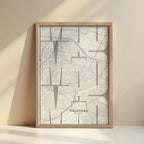 Framed Vallecas in Inseparable design, featuring the city's abbreviation in expressive typography over a detailed urban map designed in light brown and an off-white background with no border edge-to-edge print leaning against a wall