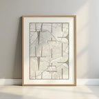Framed Vallecas in Inseparable design, featuring the city's abbreviation in expressive typography over a detailed urban map designed in light brown and an off-white background with a white margin border in a warm lit minimalist setting