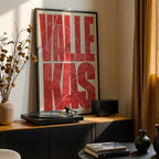 Modern interior design with a Vallecas in Extra Compressed design, where the letters are tightly squeezed to fit the city's map shape designed in red and an off-white background, displayed on a living room wall