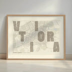 Framed Vitoria-Gasteiz in Unruled design, where the city name letters appear randomly across different lines for a truly original urban layout designed in light brown and an off-white background with a white margin border in a warm lit minimalist setting