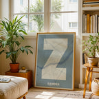 Diseño de interiores moderno con la lámina de Zamora en mi diseño la Súper Bold, un póster tipográfico donde el mapa de la ciudad se fusiona con una tipografía extra gruesa para un impacto visual moderno diseñado en gris azulado y fondo blanco roto, expuesto en la pared de un salón