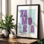 Diseño de interiores moderno con la lámina de Zamora en el diseño la Revoltosa, donde las letras del nombre aparecen aleatoriamente en diferentes líneas para un diseño urbano realmente original diseñado en púrpura y azul claro, expuesto en la pared de un salón
