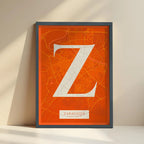Framed Zaragoza in Classic design, inspired by chiseled typography with an elegant font that creates a beautiful visual contrast designed in orange and an off-white background with no border edge-to-edge print leaning against a wall