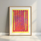 Framed Zaragoza in Extra Compressed design, where the letters are tightly squeezed to fit the city's map shape designed in yellow and fuchsia with a white margin border in a warm lit minimalist setting